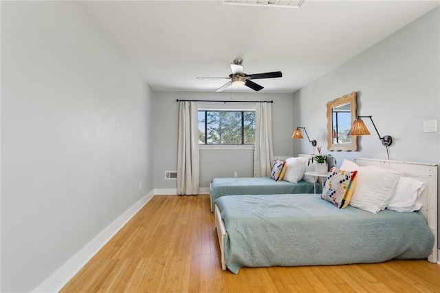 bedroom with visible vents, light wood-style flooring, and baseboards