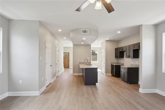 kitchen with visible vents, baseboards, light wood-type flooring, recessed lighting, and a sink