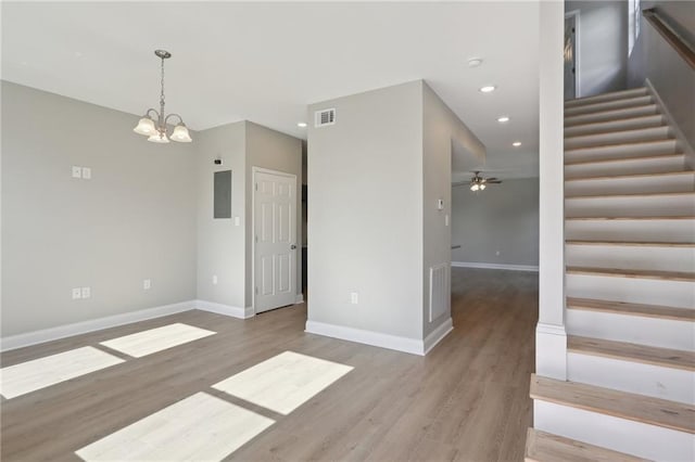 unfurnished room with visible vents, wood finished floors, recessed lighting, stairway, and baseboards