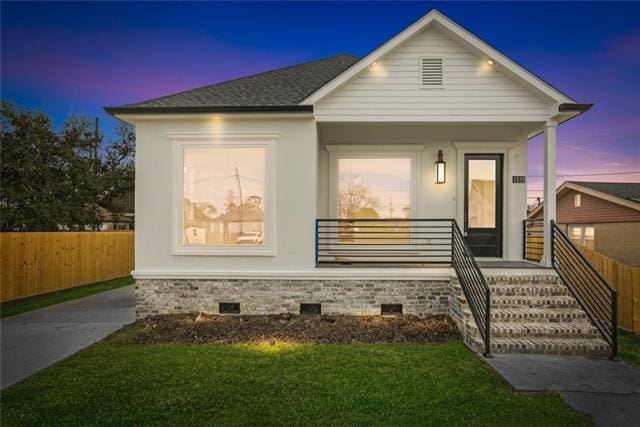 view of front of home with a porch, crawl space, roof with shingles, and fence