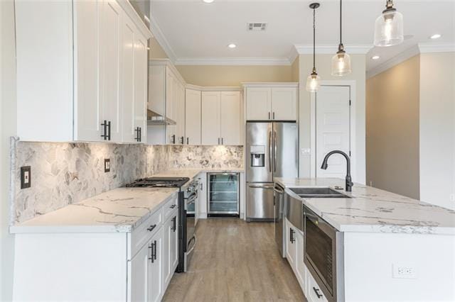 kitchen featuring visible vents, wine cooler, a kitchen island with sink, stainless steel appliances, and white cabinetry