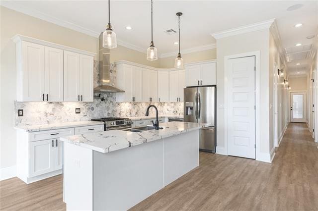 kitchen with stainless steel appliances, crown molding, a sink, and light wood finished floors