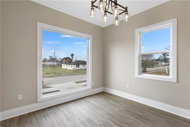 interior space featuring an inviting chandelier, baseboards, and wood finished floors