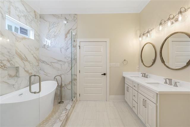 full bath featuring ornamental molding, a soaking tub, a sink, and double vanity