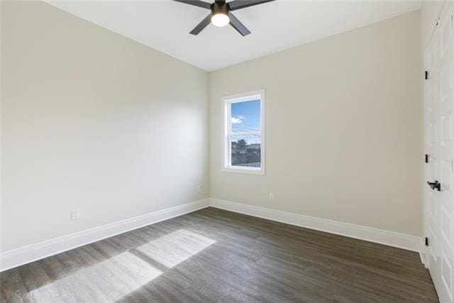 unfurnished room with ceiling fan, baseboards, and dark wood-type flooring