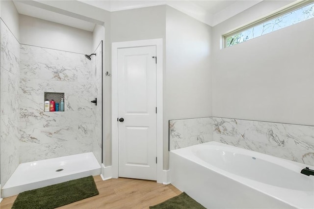 bathroom with wood finished floors, a bath, and a shower stall