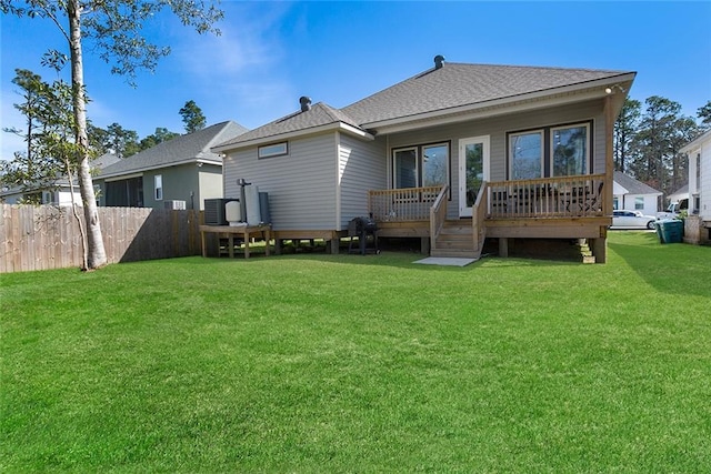 back of house featuring roof with shingles, central air condition unit, a lawn, fence, and a deck