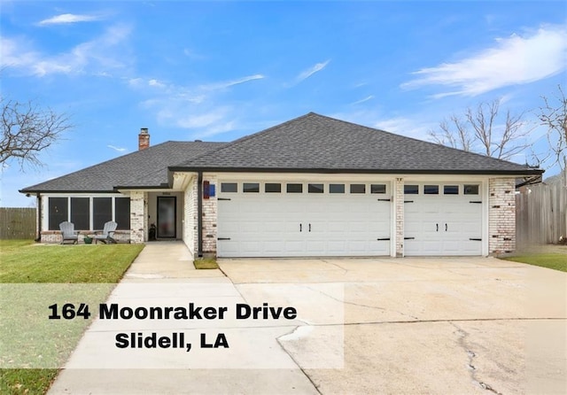 view of front of house featuring a garage, concrete driveway, brick siding, and a front lawn