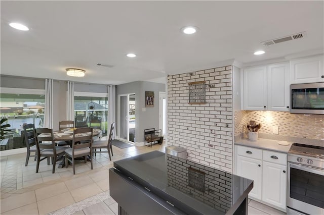 kitchen featuring appliances with stainless steel finishes, backsplash, visible vents, and white cabinetry