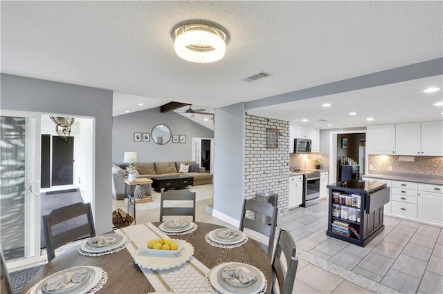 dining area featuring vaulted ceiling with beams, ceiling fan, a textured ceiling, and recessed lighting