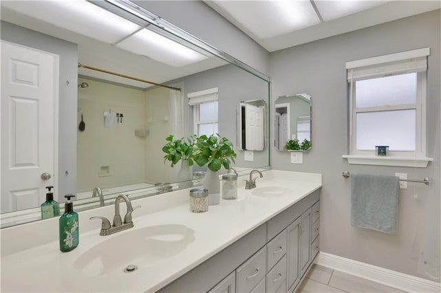 full bath with double vanity, a shower with curtain, a sink, and baseboards