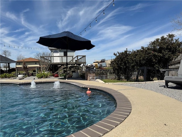 view of swimming pool featuring fence