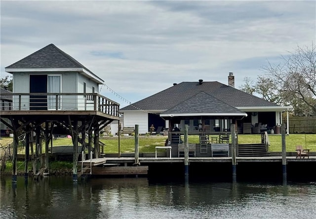 dock area with a yard and a deck with water view