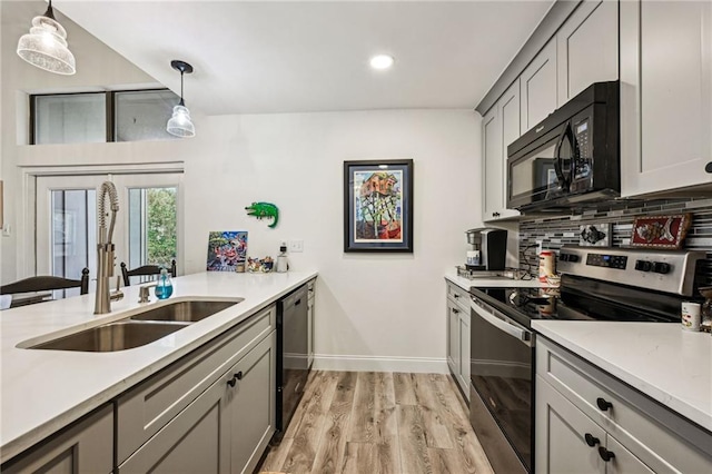 kitchen with decorative backsplash, dishwasher, stainless steel electric range, black microwave, and a sink