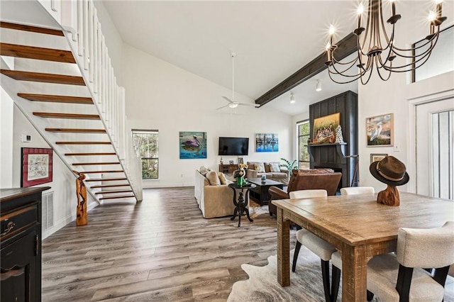 dining space with a healthy amount of sunlight, beamed ceiling, stairway, and wood finished floors