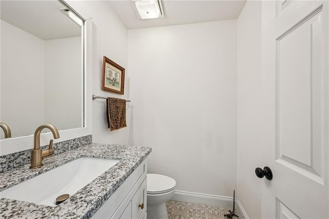 half bath featuring visible vents, baseboards, vanity, and toilet