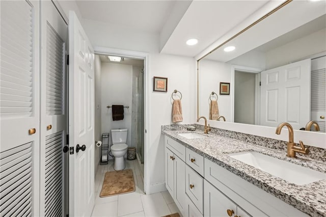 full bathroom with double vanity, a sink, toilet, and tile patterned floors