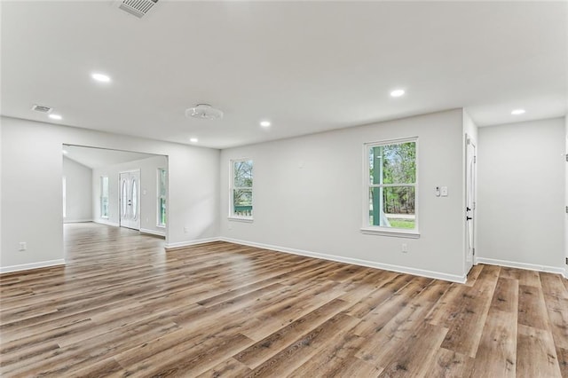 spare room with baseboards, visible vents, wood finished floors, and recessed lighting