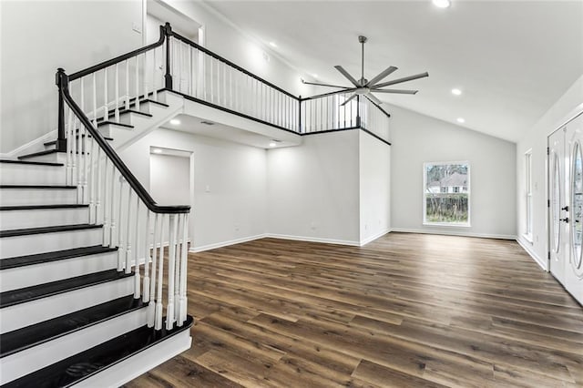 foyer entrance featuring stairway, a towering ceiling, baseboards, and wood finished floors