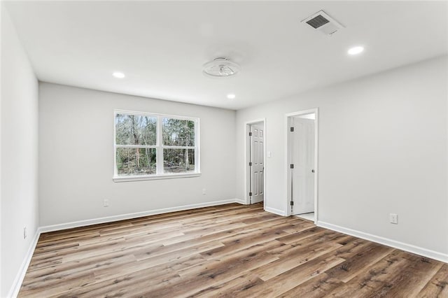 spare room featuring wood finished floors, visible vents, and recessed lighting