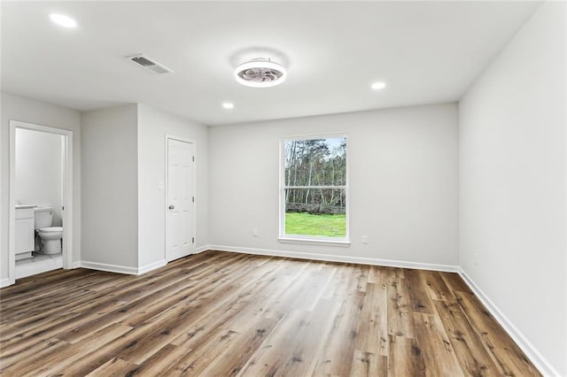 42224 Surrey Ln, Slidell, LA 70461 - unfurnished bedroom with wood finished floors, baseboards, ensuite bath, and recessed lighting