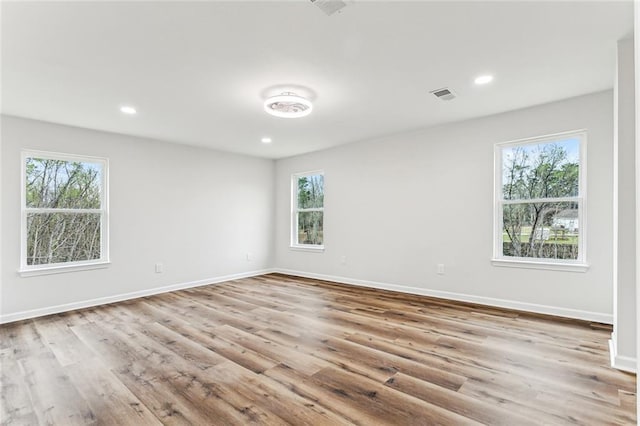 unfurnished room featuring recessed lighting, visible vents, baseboards, and wood finished floors