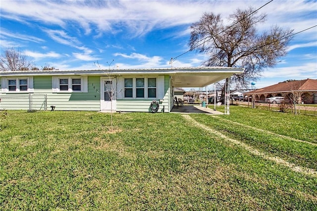 view of front of house with driveway, fence, a front lawn, and a carport