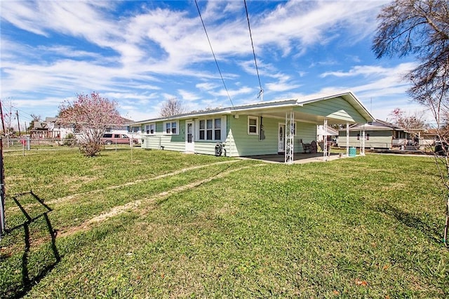 rear view of property featuring a patio area, fence, and a lawn