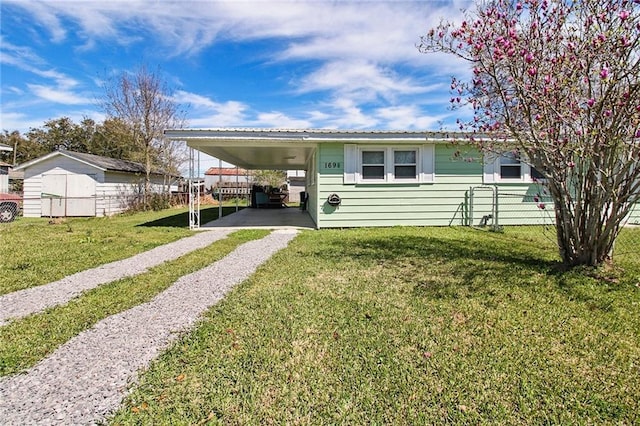 view of front of house with a carport, a front yard, and driveway