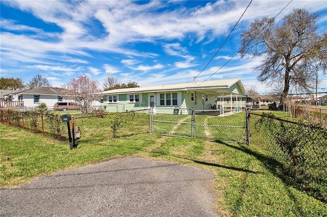 single story home with a front lawn, a fenced front yard, and a gate