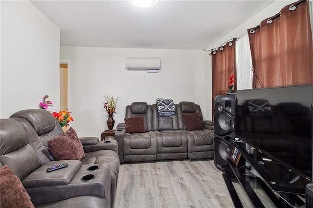 living room with light wood-style floors and an AC wall unit