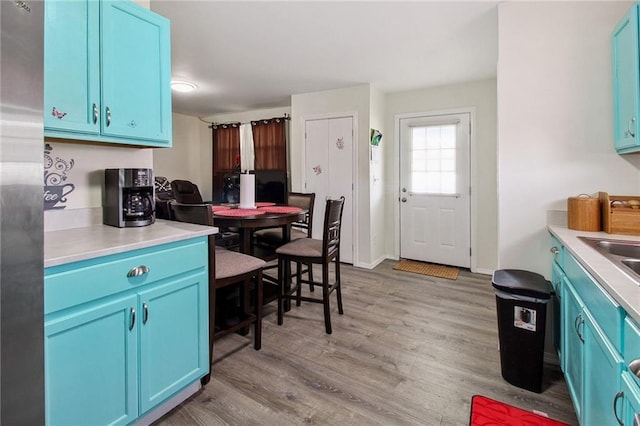 kitchen featuring light wood finished floors and blue cabinetry