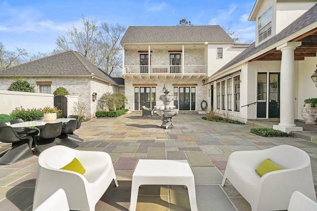 view of patio featuring a balcony and fence