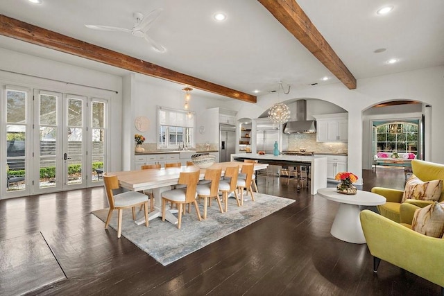 dining space featuring ceiling fan, arched walkways, recessed lighting, dark wood-style flooring, and beam ceiling