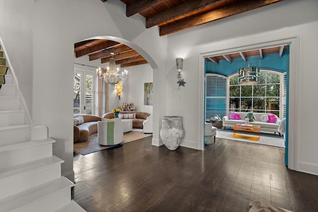 interior space with arched walkways, an inviting chandelier, wood ceiling, beam ceiling, and stairs