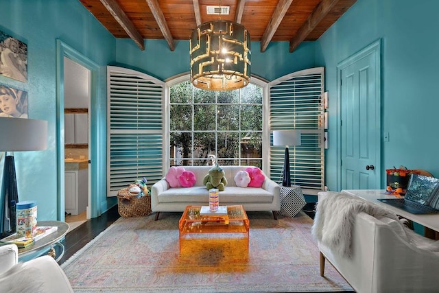 living area featuring beam ceiling, wooden ceiling, visible vents, and a chandelier