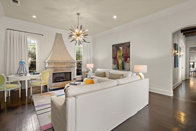 living area with dark wood finished floors, a notable chandelier, a fireplace, and arched walkways