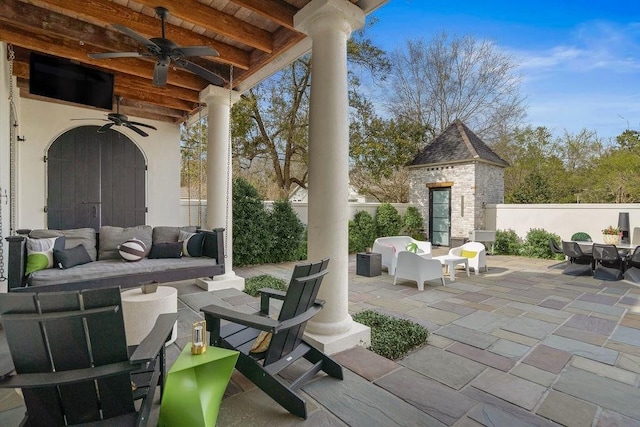 view of patio / terrace featuring an outdoor living space, a ceiling fan, outdoor dining area, an outbuilding, and fence