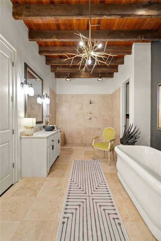 bathroom featuring a chandelier, a freestanding bath, beam ceiling, wooden ceiling, and vanity