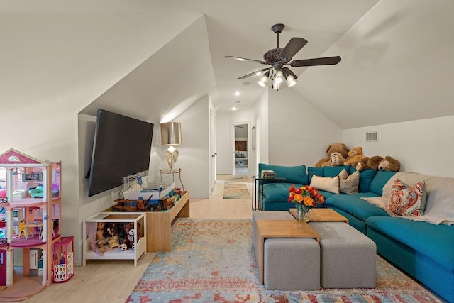 living room with visible vents, light wood-style flooring, a ceiling fan, and lofted ceiling