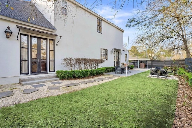 back of house featuring stucco siding, a lawn, fence, a shingled roof, and a patio area