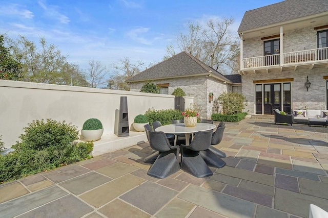 view of patio / terrace with outdoor dining space, french doors, and a balcony