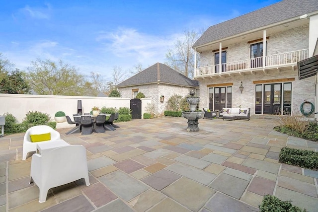 view of patio featuring outdoor dining area, an outdoor hangout area, a balcony, and fence