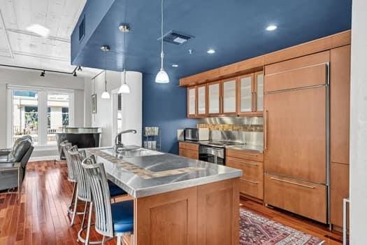 909 Lafayette St Unit 6, New Orleans, LA 70113 - kitchen with glass insert cabinets, a sink, visible vents, built in fridge, and dark wood-style flooring