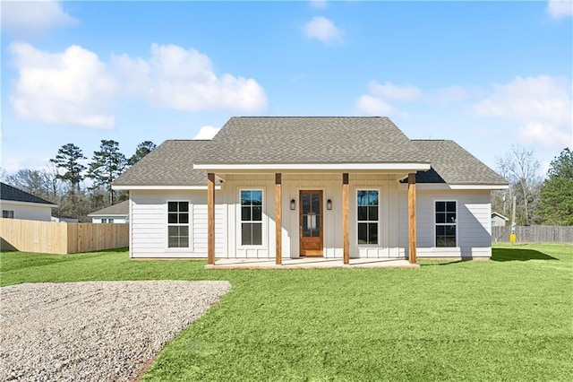 view of front of property featuring a shingled roof, board and batten siding, and fence