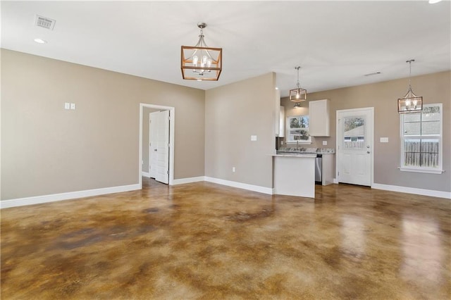 interior space with visible vents, white cabinets, finished concrete flooring, baseboards, and an inviting chandelier