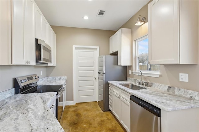 kitchen featuring stainless steel appliances, a sink, visible vents, baseboards, and white cabinetry