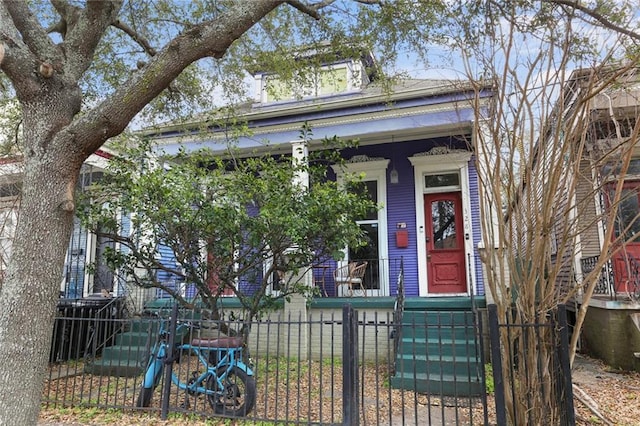 shotgun-style home featuring a fenced front yard