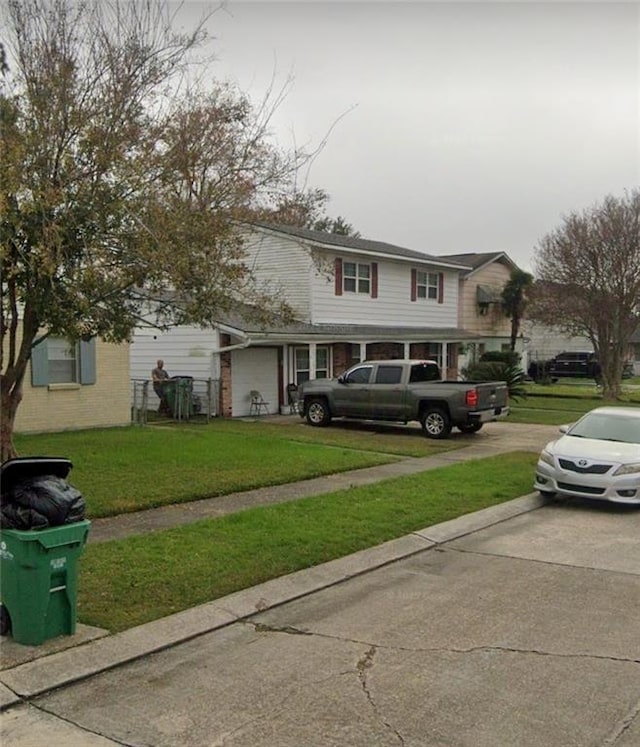 traditional-style house featuring driveway, brick siding, and a front yard