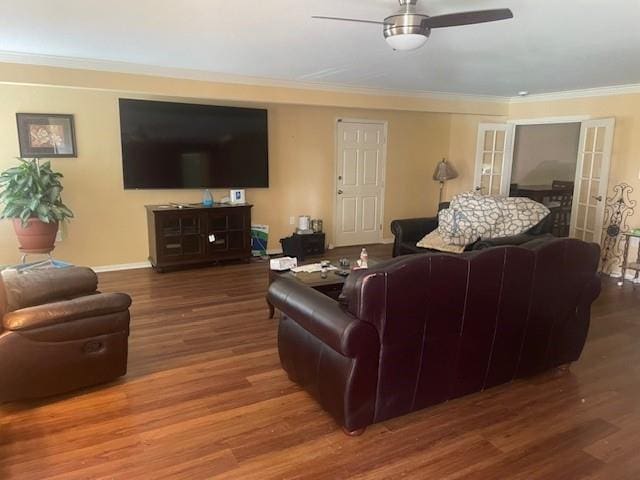 living room featuring baseboards, crown molding, a ceiling fan, and wood finished floors